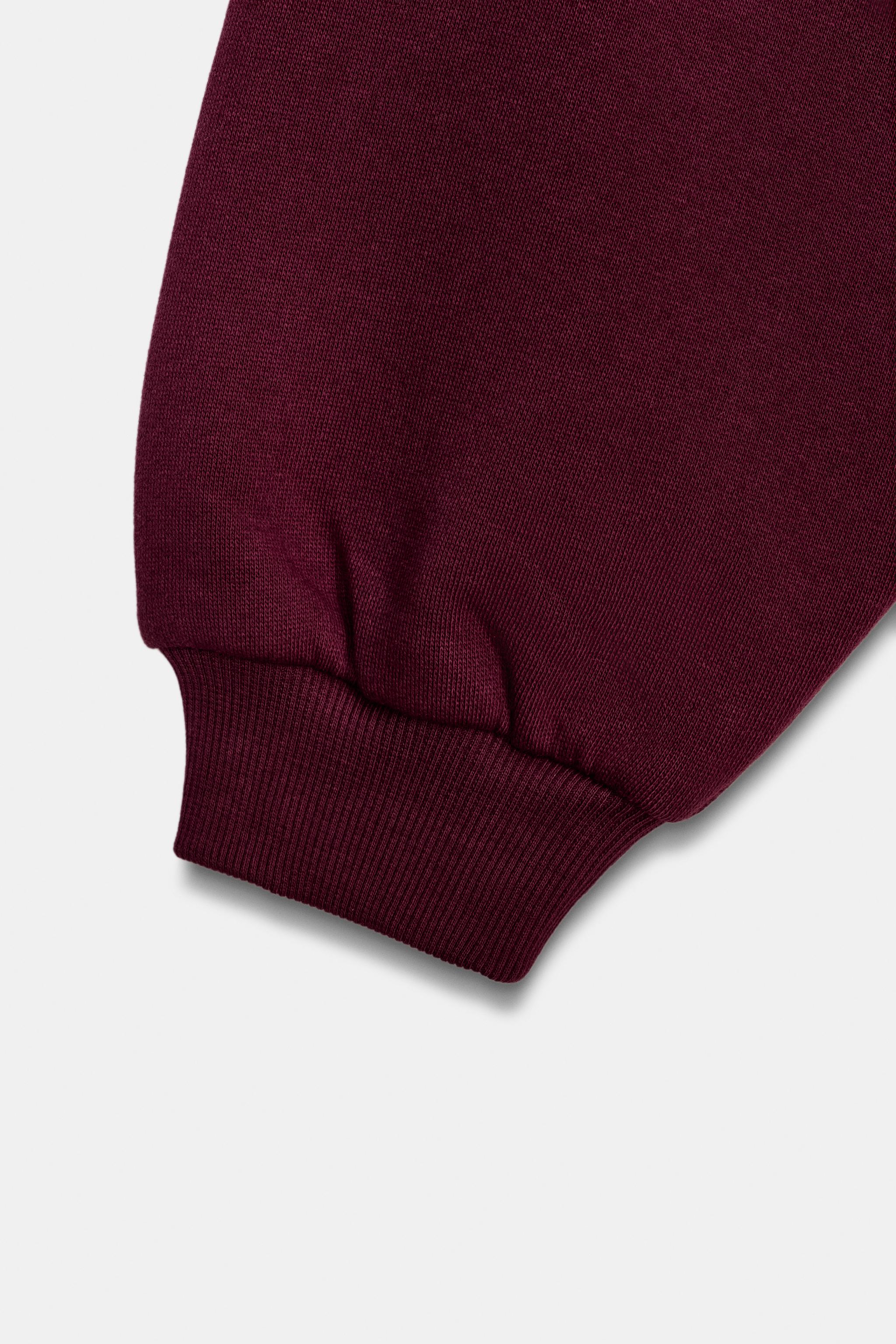 RUFFLED VARSITY SWEATSHIRT